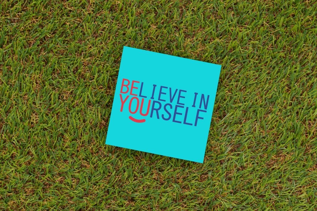 A vibrant note saying 'Believe in Yourself' placed on green turf, capturing motivation and optimism.