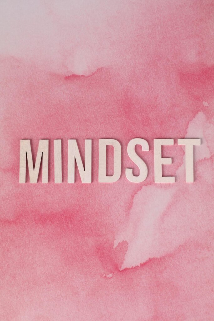 Inspirational mindset text on pink watercolor background for motivational themes.